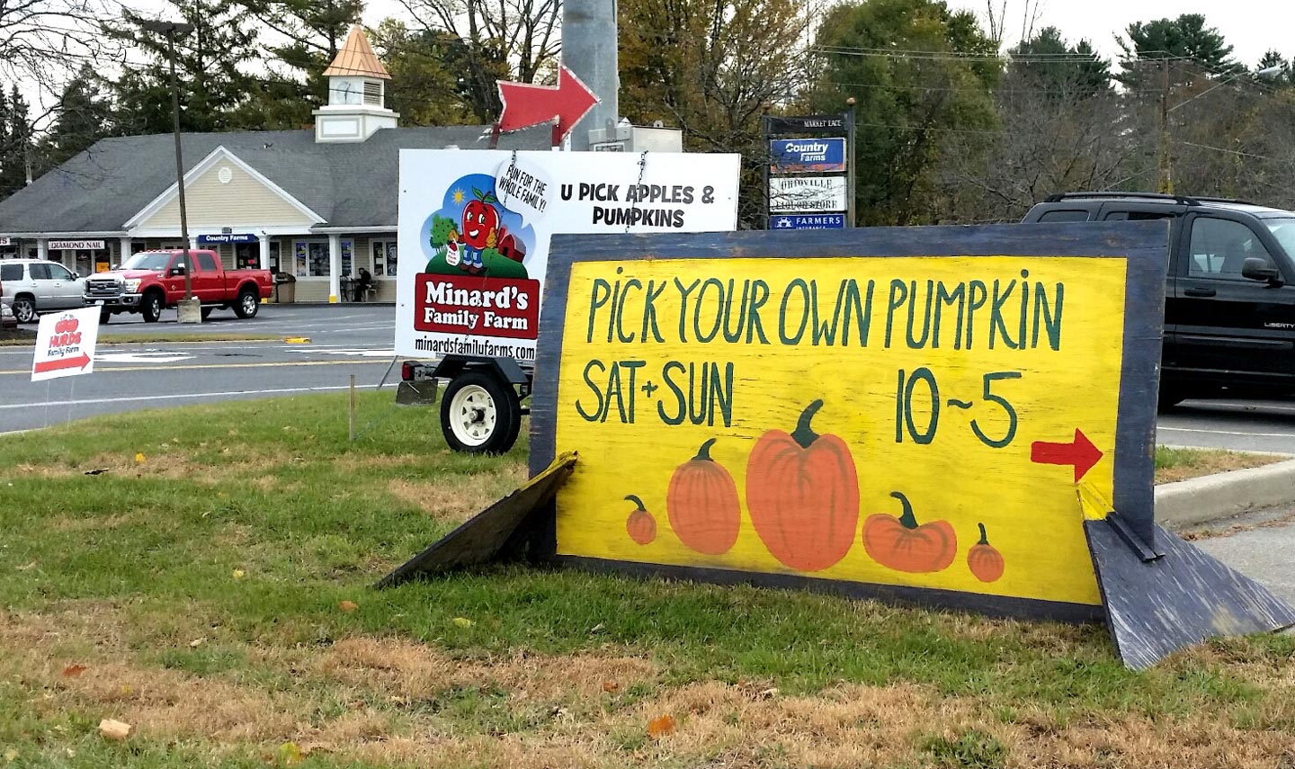 Amongst the cacophony of anthropomorphic tree fruits and squash, a handcrafted sign with a bright color palette is a welcomed change.