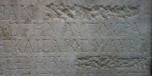 Slab of carved stone, perhaps early Roman era, on display at British Museum, names have been chipped away to remove someone's legacy