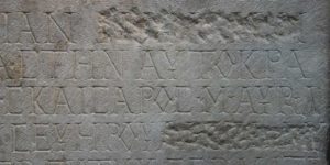 Slab of carved stone, perhaps early Roman era, on display at British Museum, names have been chipped away to remove someone's legacy