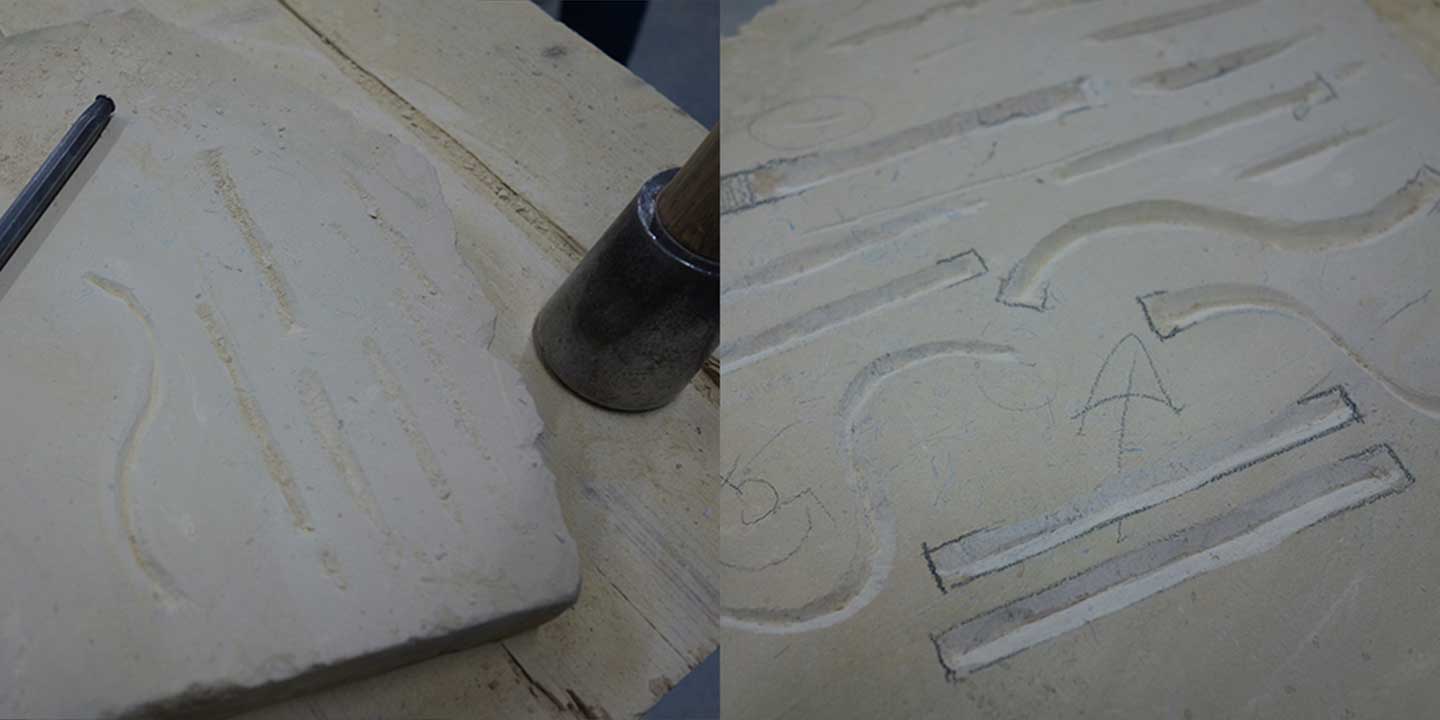 Close up image of first attempt at carving straight lines and s-curves into stone