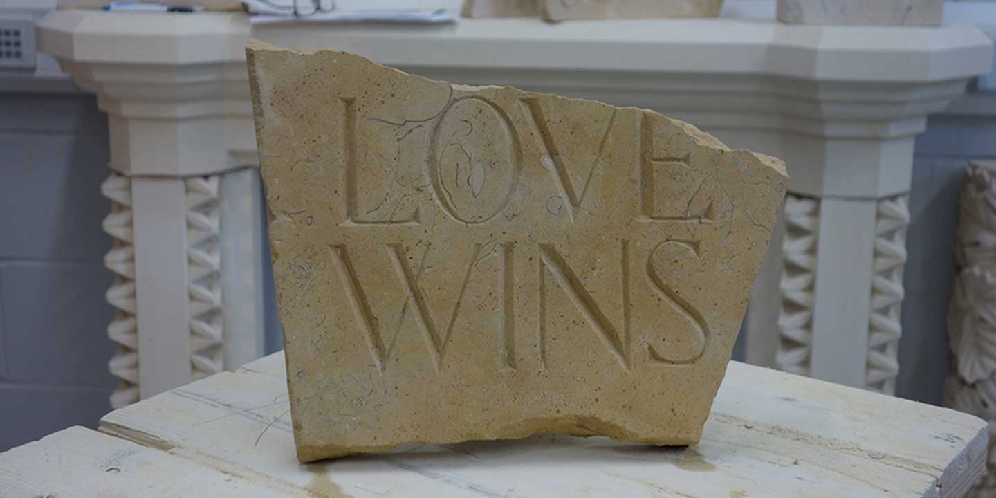 Showcase photo of final class assignment, which is a stone with words LOVE WINS; photo taken inside Ministry of Stone studio, Lincoln, England
