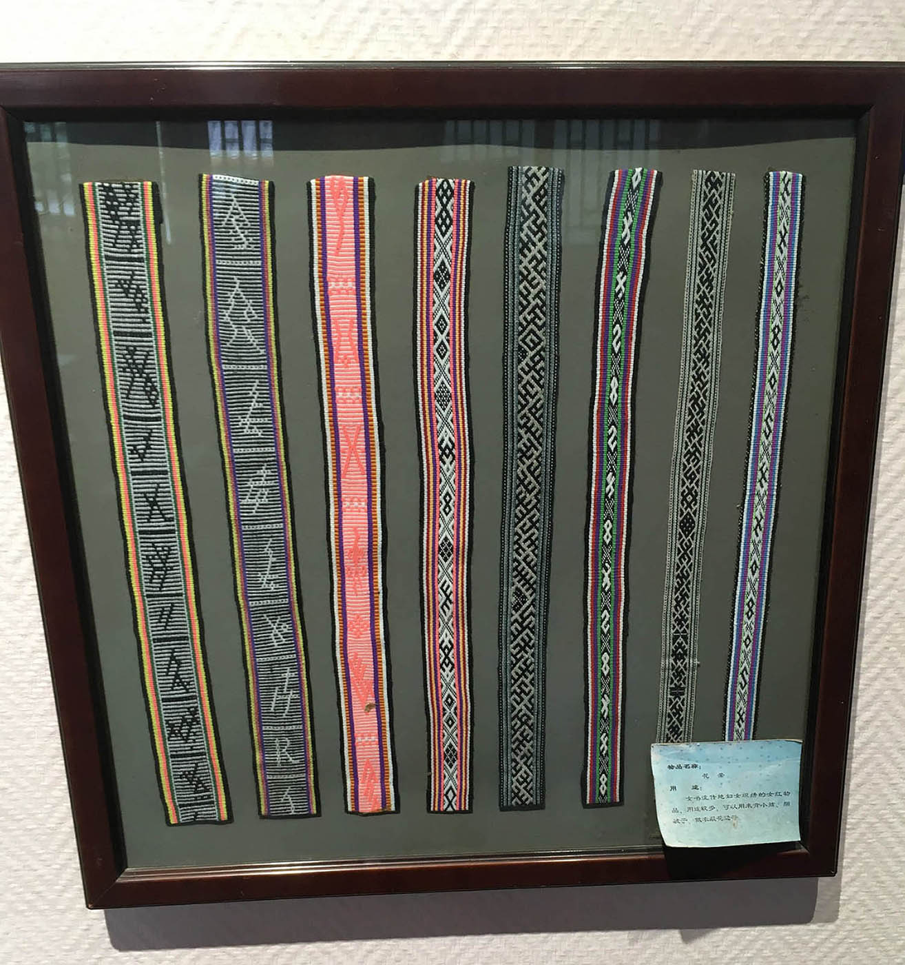 Silk belts with Nüshu characters sewn in as patterns in a frame