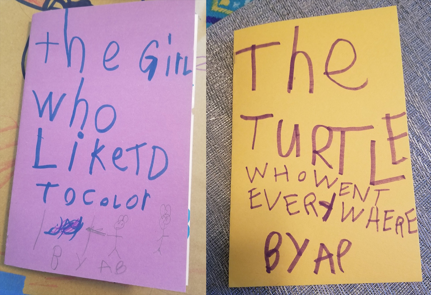 book covers on purple and yellow construction paper, handwritten by a child,