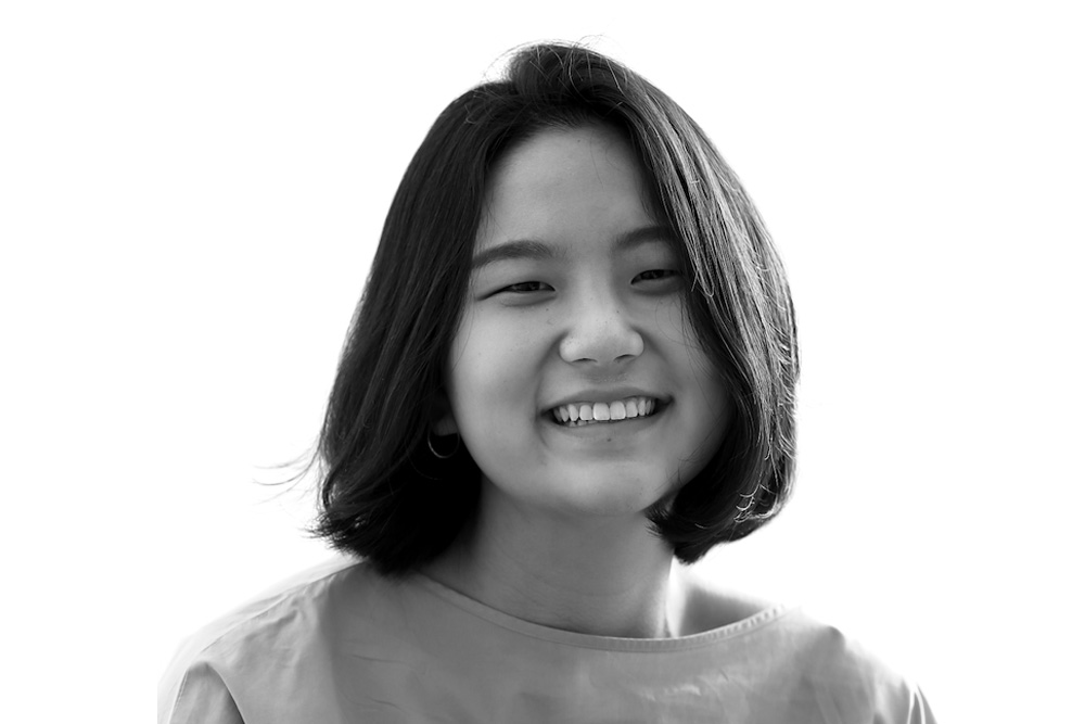 black and white headshot of a woman speaking at a podium