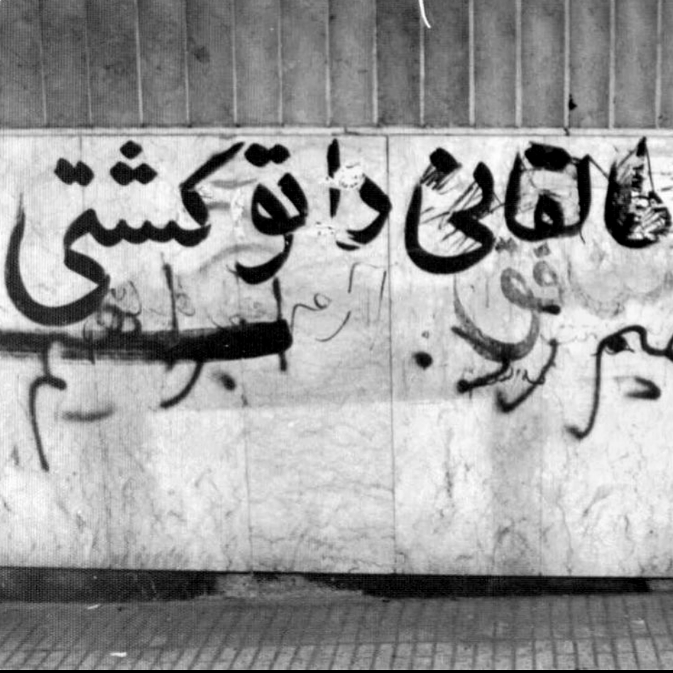 black and white image of spray painted and handwritten messages on a wall
