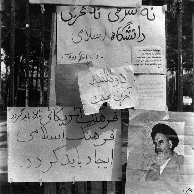 handwritten lettering on paper taped onto a metal fence