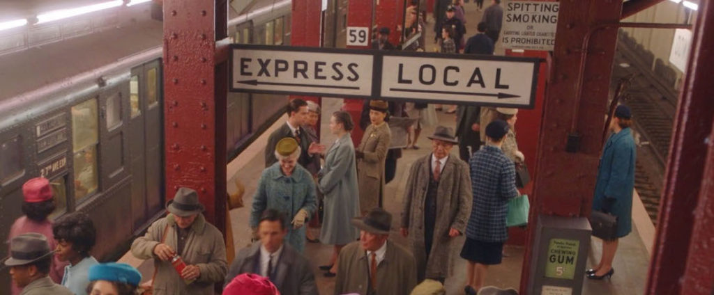 Screenshot of subway scene in the Marvelous Mrs. Maisel looking down stairs at crowd of people coming off train.