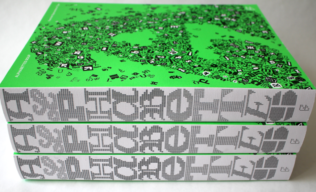 a stack of three books showing the spine of Alphabettes Soup with the word ALPHABETTES set vertically on the spine. The cover is bright green and features a large A made of smaller characters and glyphs